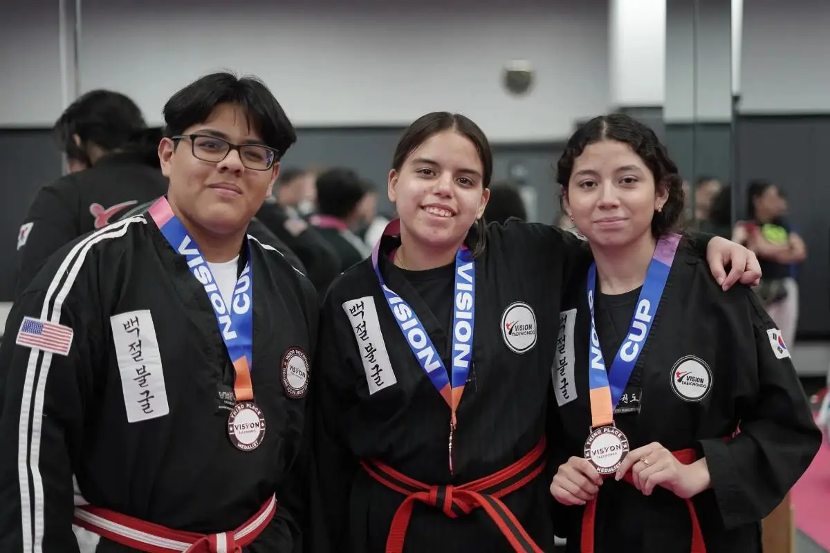 Taekwondo students celebrating tournament medals after competition