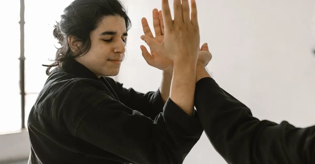 self defense techniques for beginners class student wearing black gi blocking an attack using hands